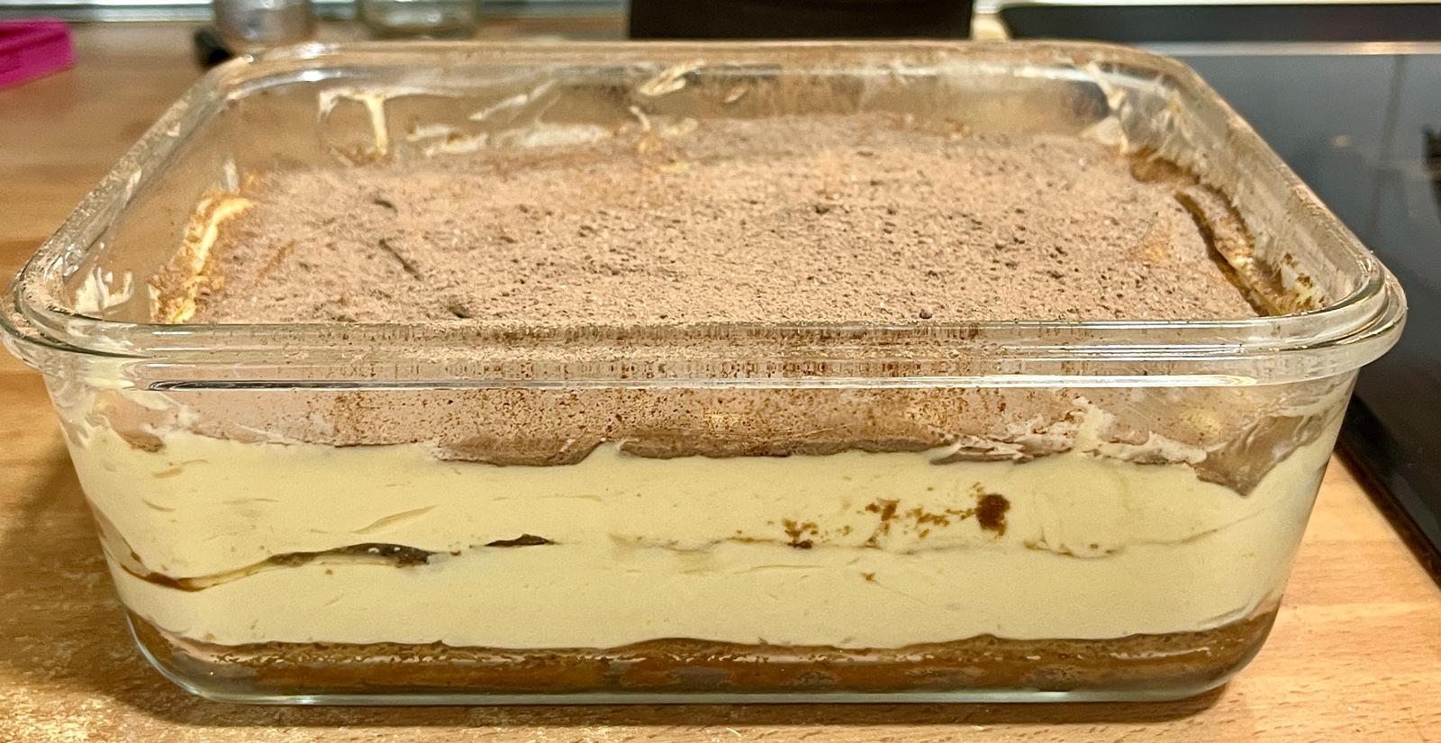 Foto de un tiramisú en un tupper con dos pisos.